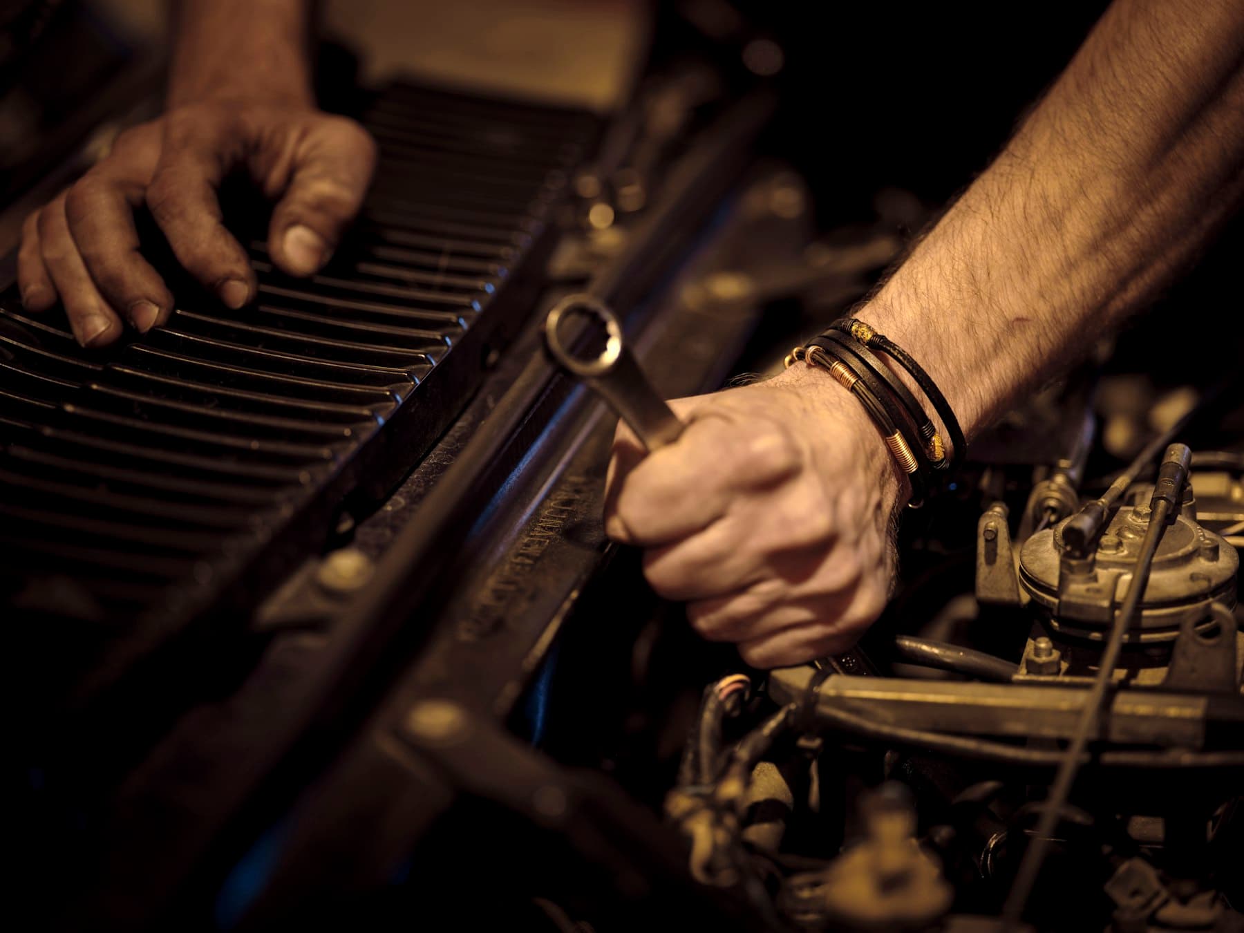 Ruky mechanika pri práci na motore